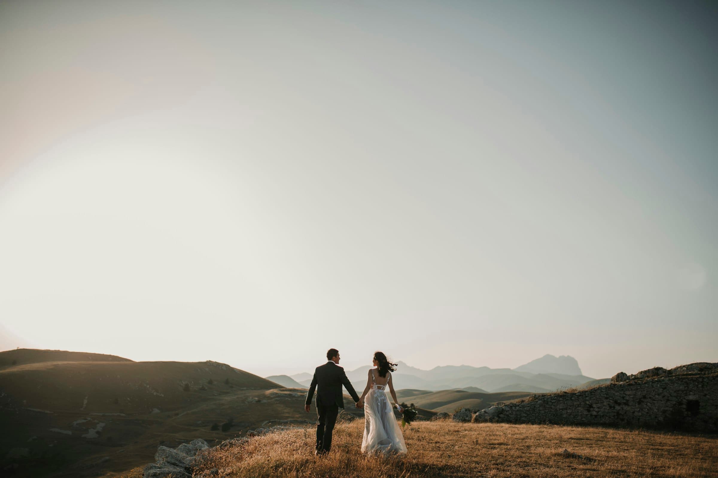 Couple walking hand in hand through a golden-hour field near Franklin, Indiana