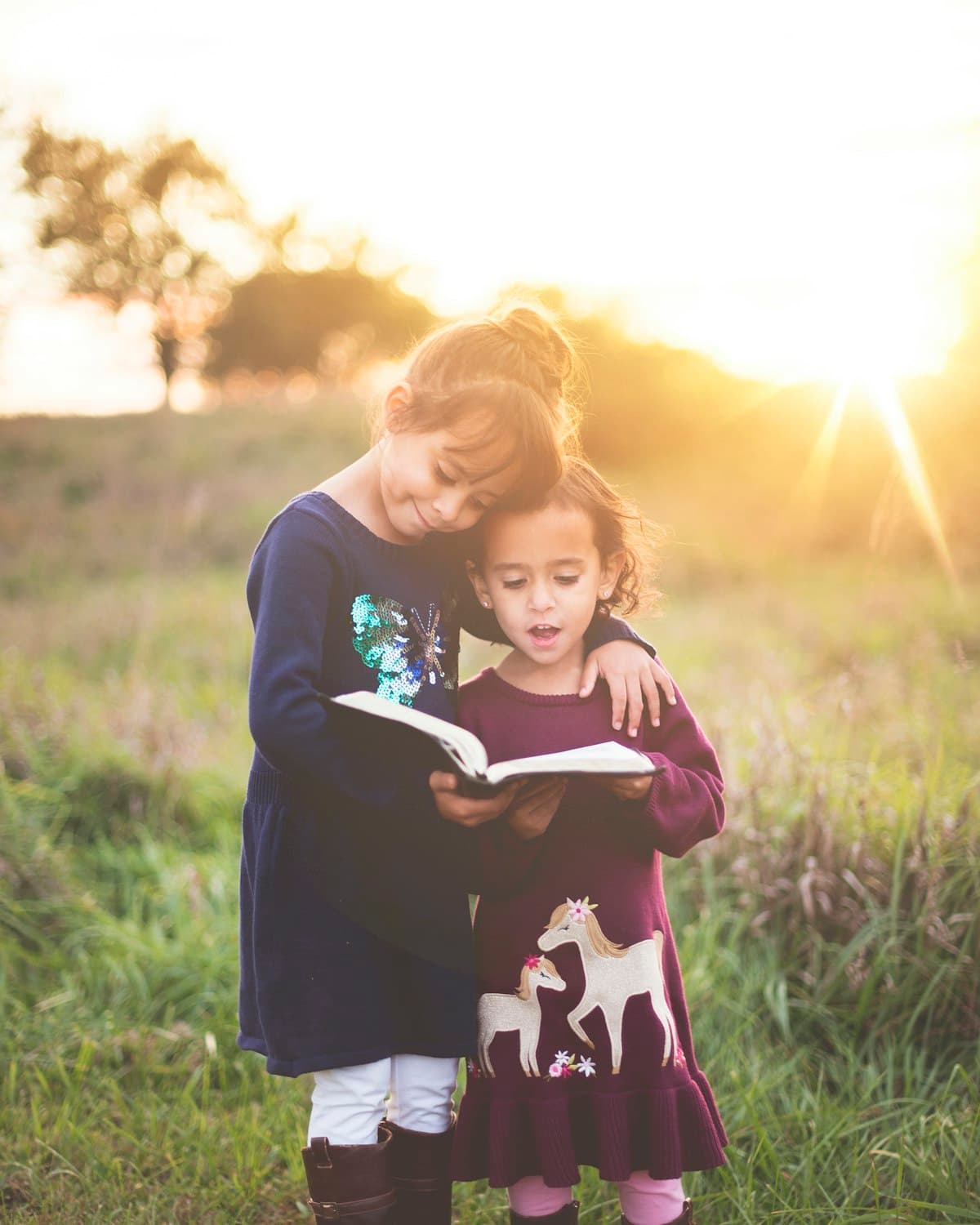 Children running through tall grass in warm evening light