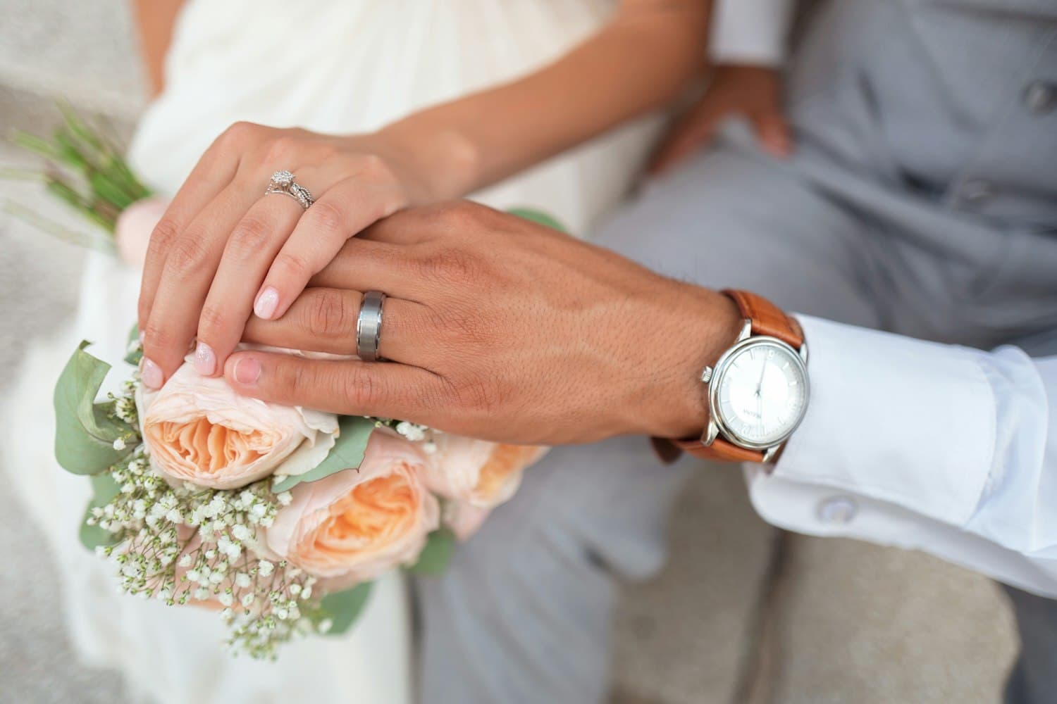 Detail of hands and wedding rings in soft window light