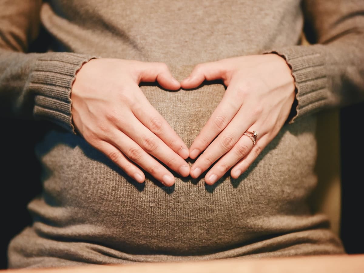 Expecting mother cradling her bump in golden light